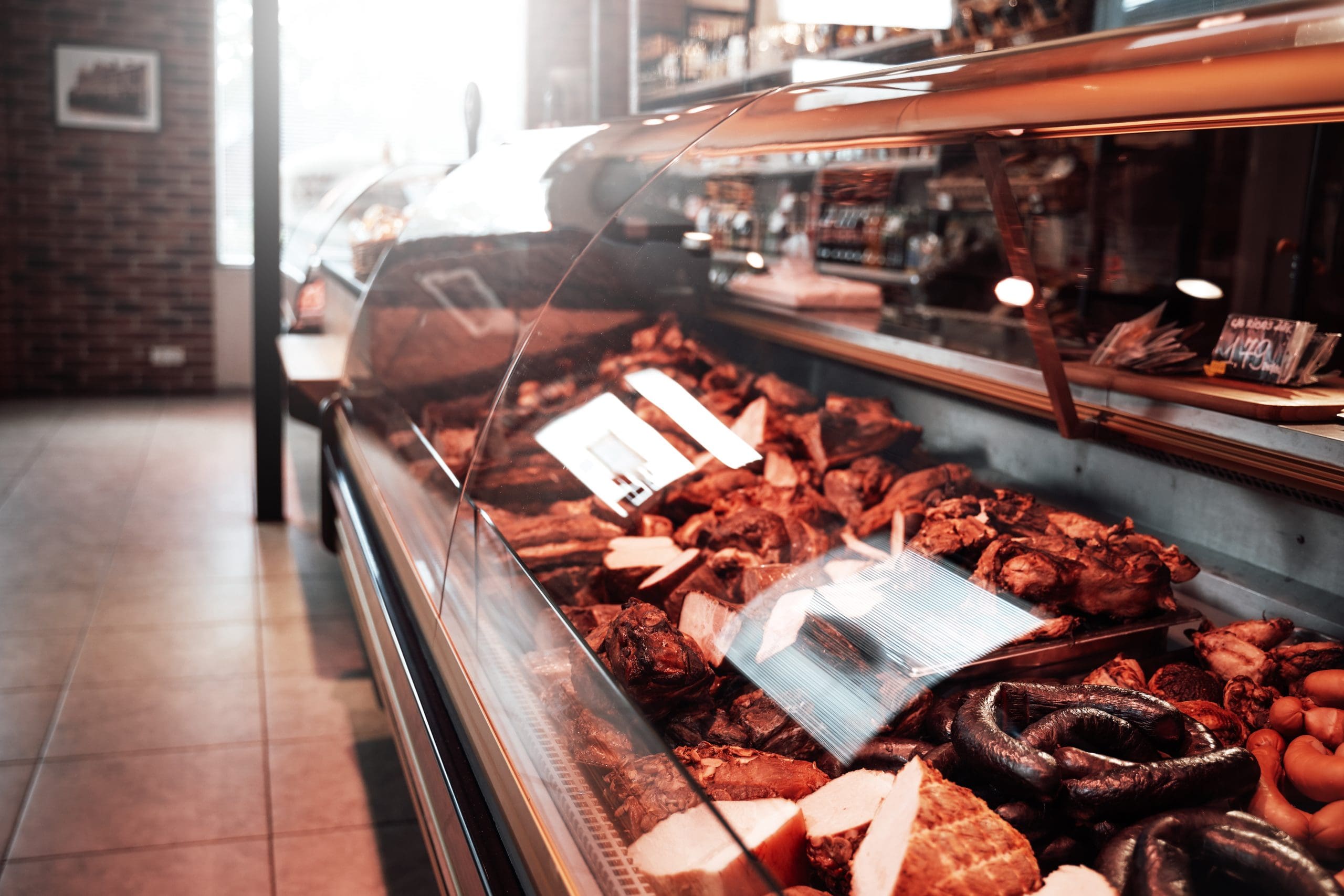 Modern meat shop and its refrigerator full filled with huge variation of choice raw and smoked meat