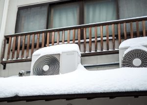 Snow-covered air conditioning units outside