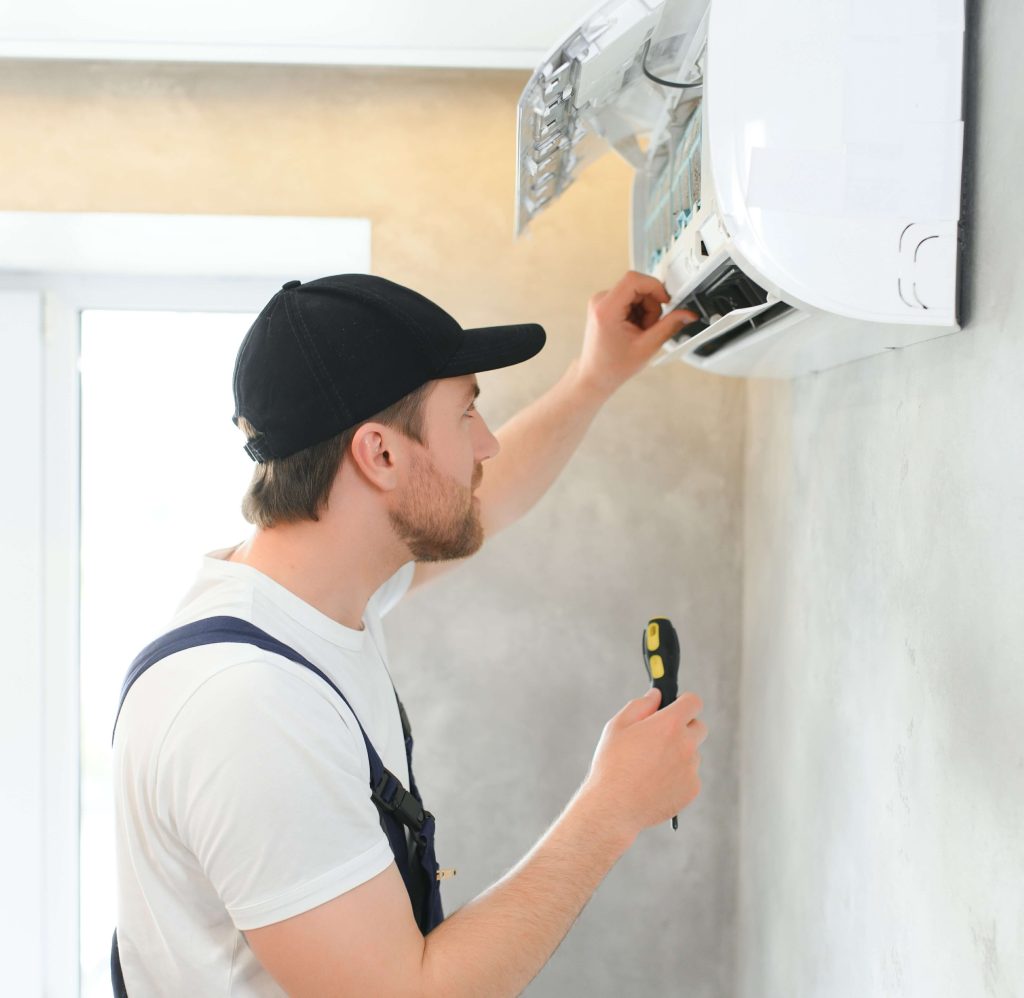 portrait-of-a-young-man-adjusting-air-conditioning